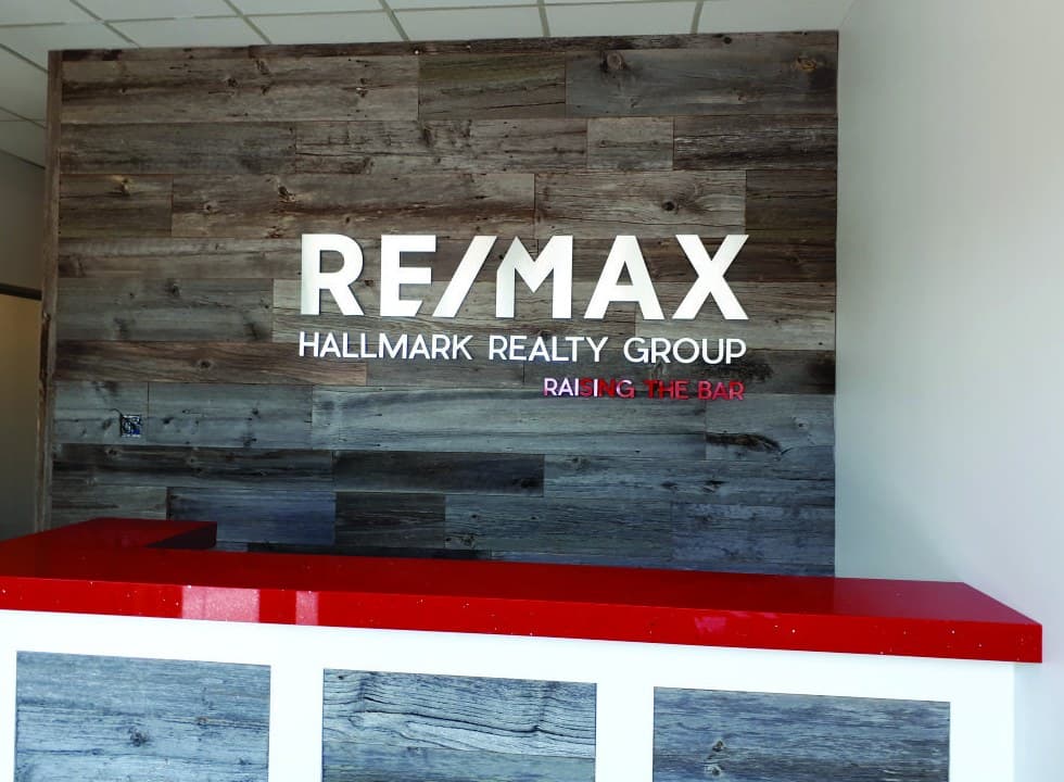 RE/MAX Hallmark Realty reception feature wall with dimensional letters on barnwood